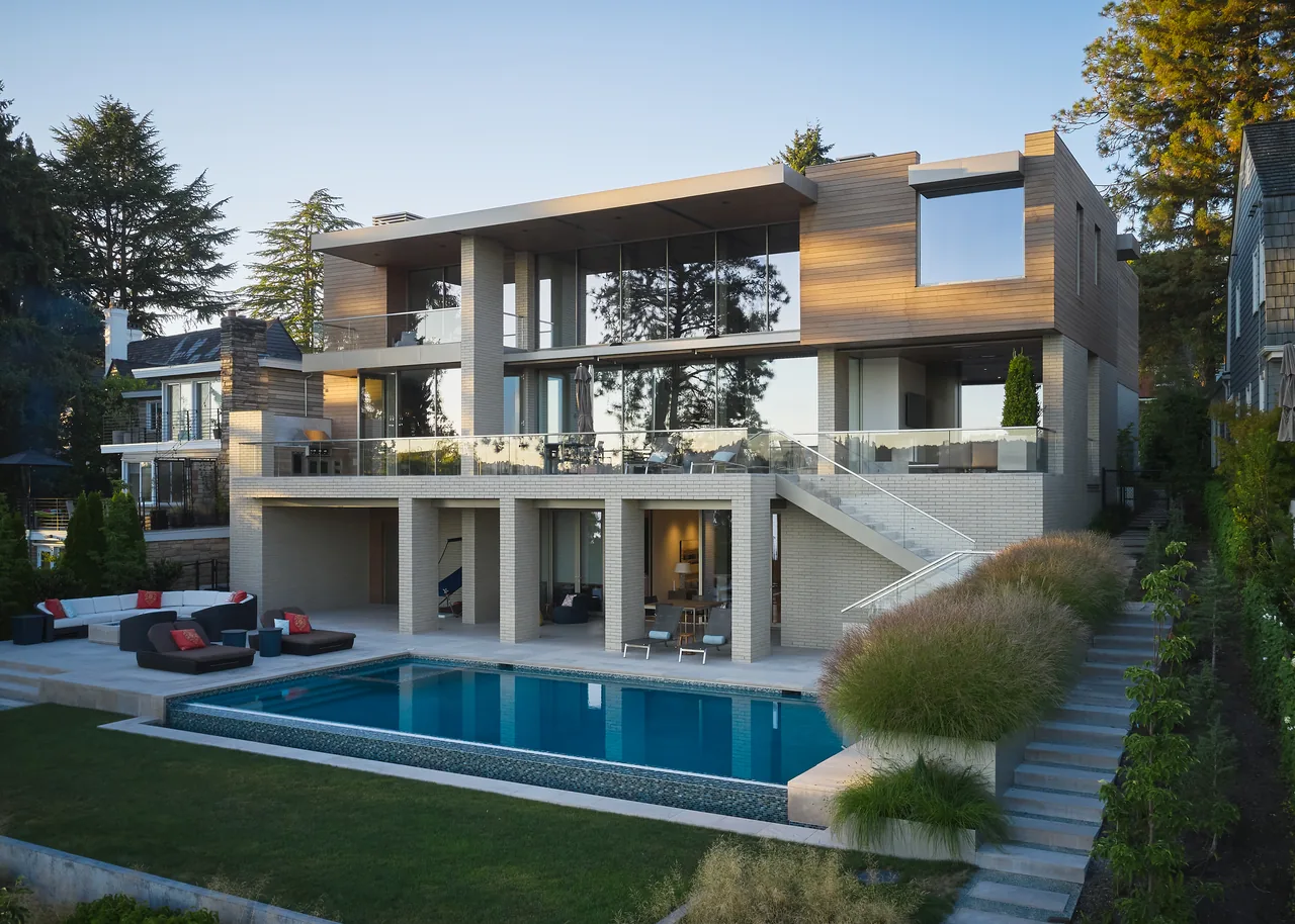 The Union Bay Residence features a modern two-story facade with extensive glazing and a backyard pool.