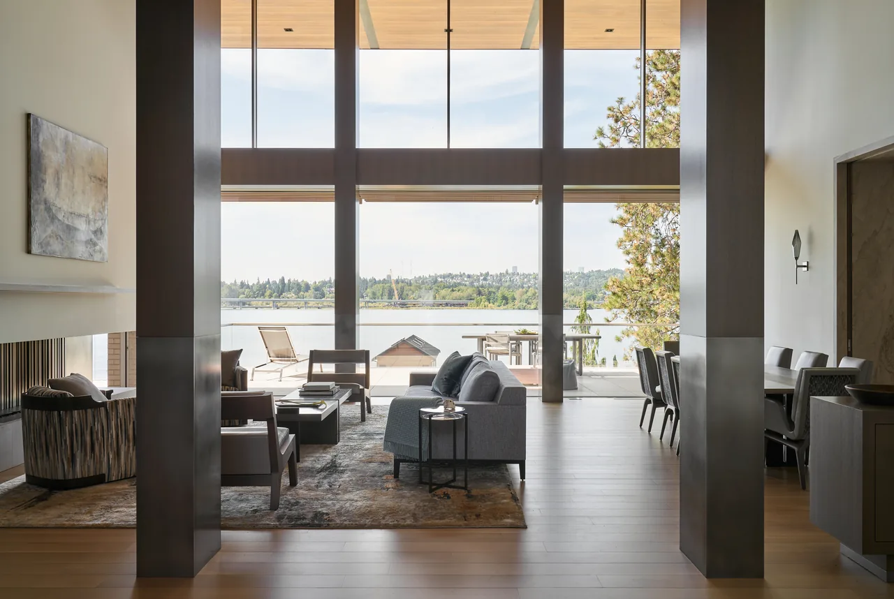 The Union Bay Residence features floor-to-ceiling glazing revealing a waterfront lake view from the living room.