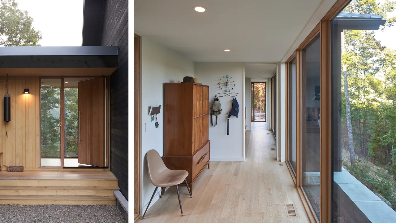 Entry area and adjacent hallway of Short Mountain House with wood elements and glass window wall toward wooded exterior.