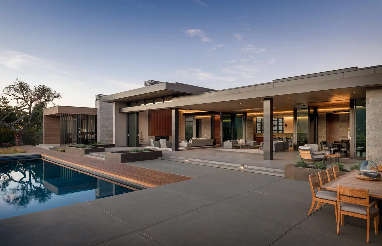 Portola Valley House features a modern flat-roof design with extensive covered patio space and a pool.