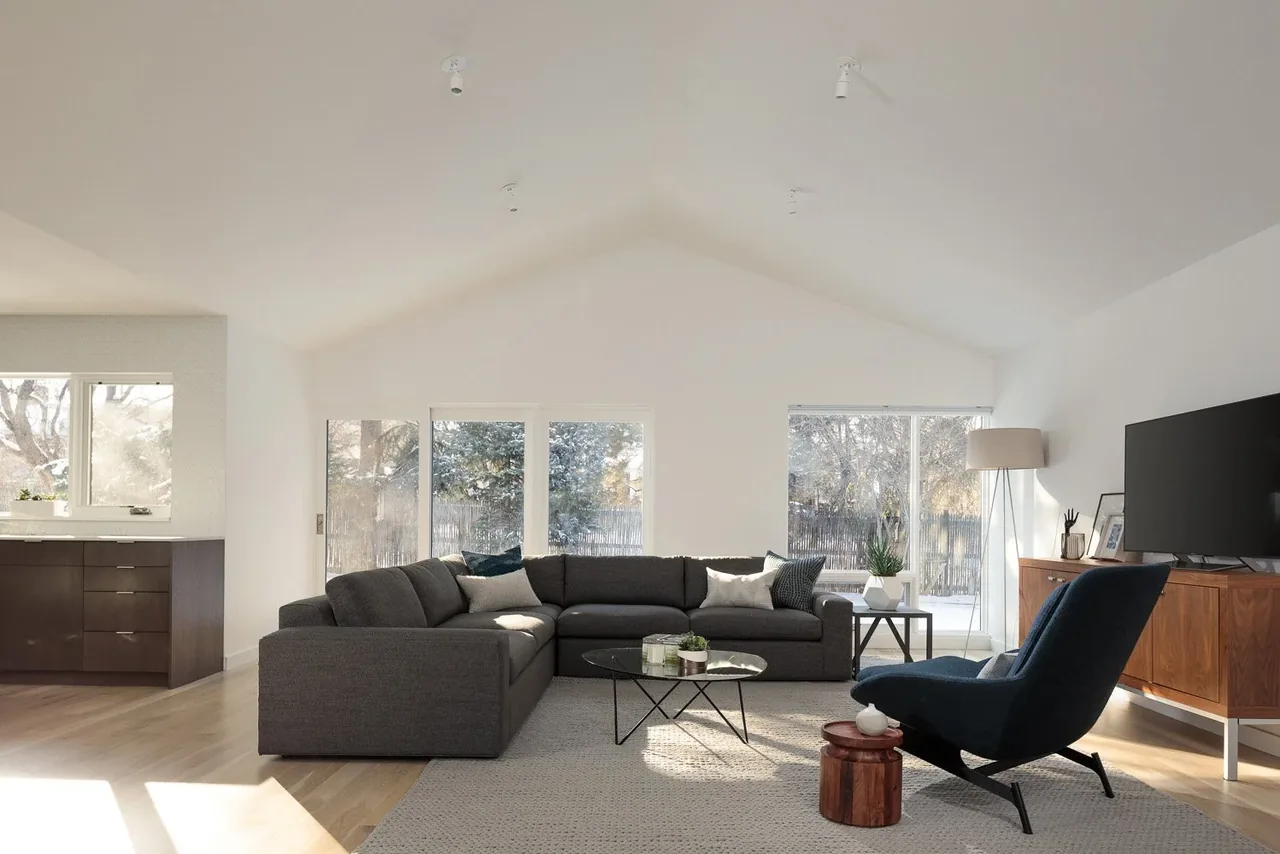 The Krameria Residence living room features vaulted ceilings and floor-to-ceiling windows that bring in natural light.