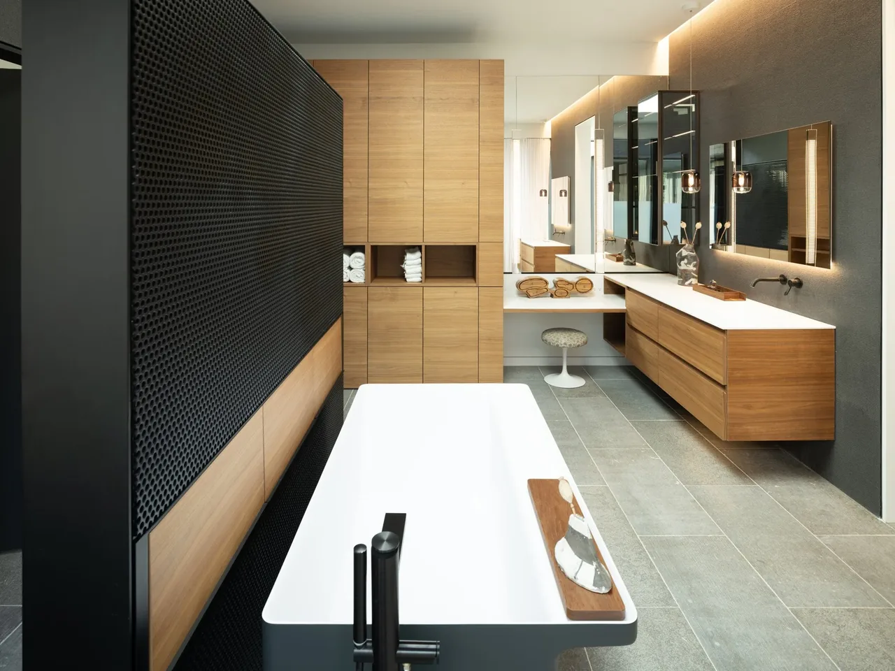 Hunter Residence bathroom features wood cabinetry and a rectangular freestanding tub with black fixtures.