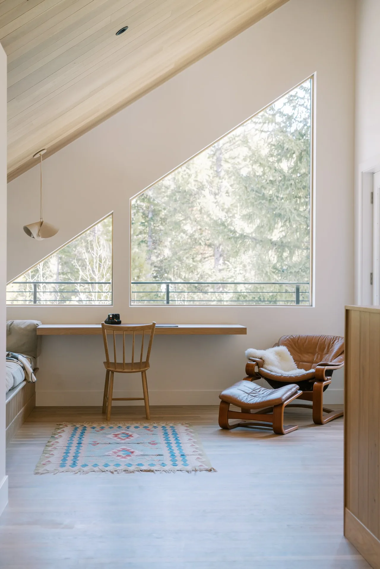 WINTER PARK RESIDENCE features a minimalist workspace with large triangular windows and light wood finishes by BARI Architecture.
