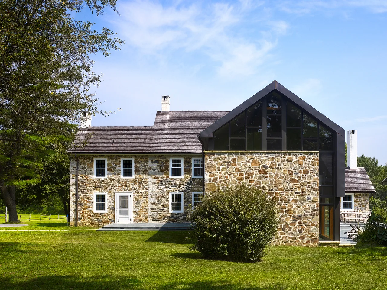 Elverson Addition features a historic stone facade with a modern metal roof addition and large glass windows.