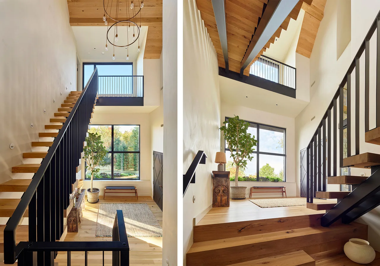 Bucks Retreat features a floating wood staircase with black railings and a vaulted ceiling with exposed wood beams.