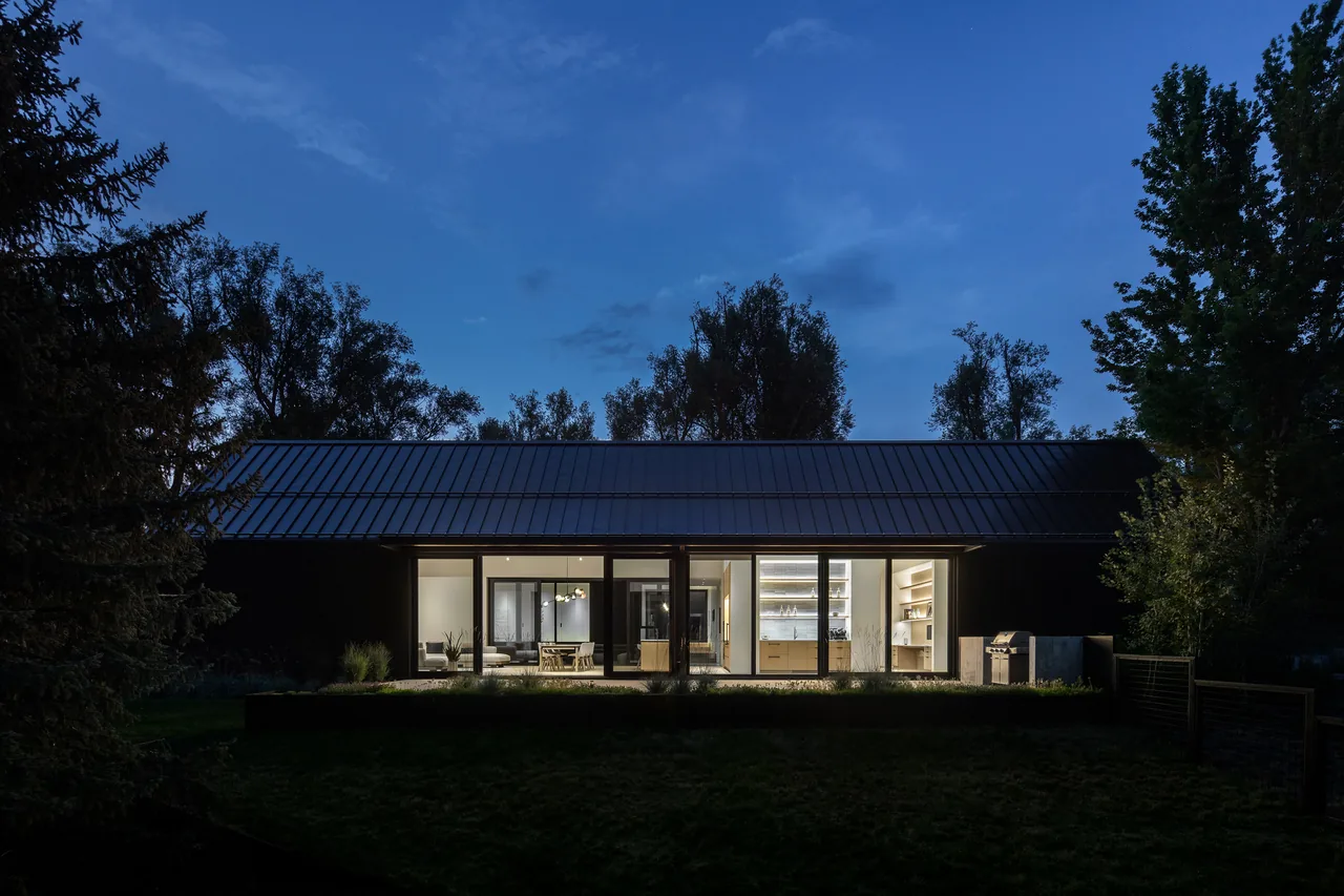 Three Gables house by Piché Architecture features three gabled roofs with nighttime lighting and visible interior spaces.
