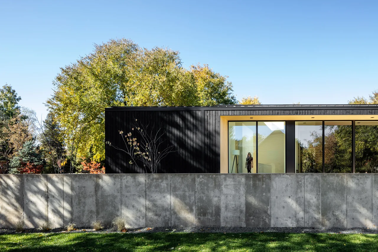 Vista Drive Pavilion shows black vertical siding with large glass windows and a concrete wall in front.