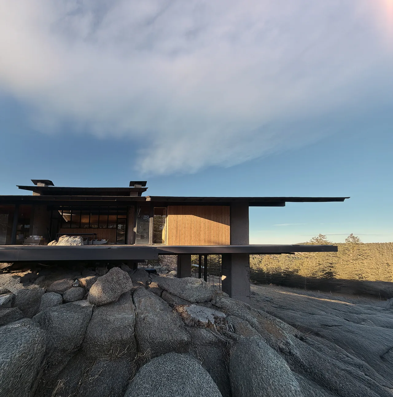 Sentinel Rock features a modern design with wide roof overhangs and is perched on rocky terrain.
