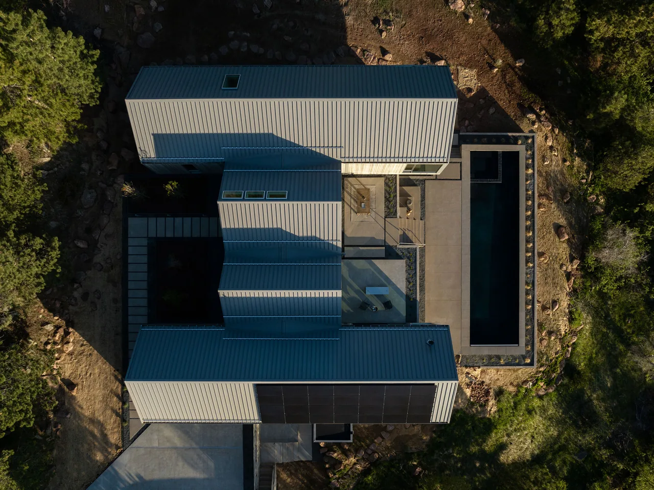 Villa H features standing seam metal roofs and a narrow pool in the rear courtyard.