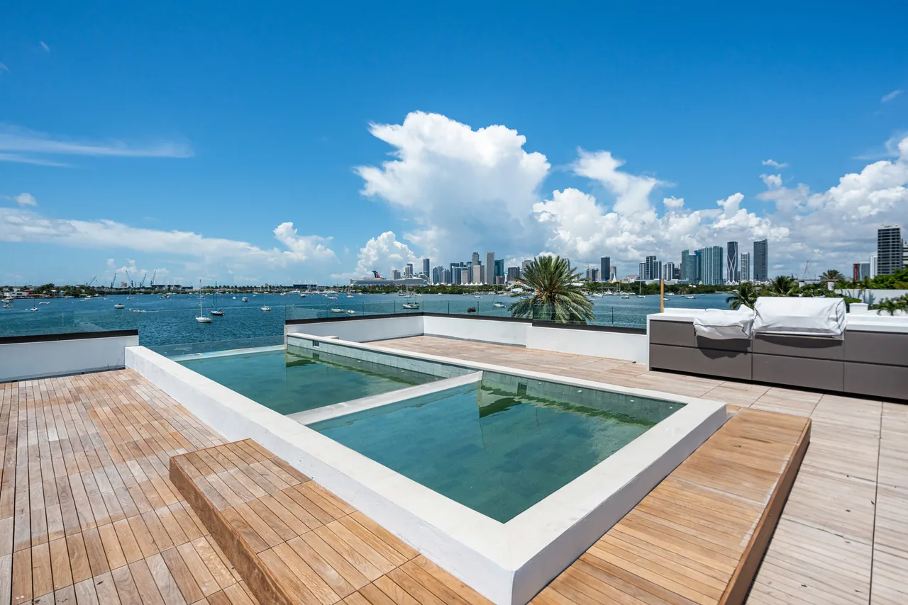 Rooftop pool and deck with waterfront views in Venetian Island II project by TOGU Design.