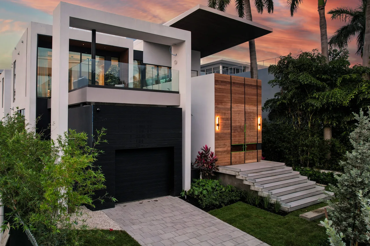 Venetian Island I features modern architecture with a wood front door, glass railings, and black and white exterior materials.
