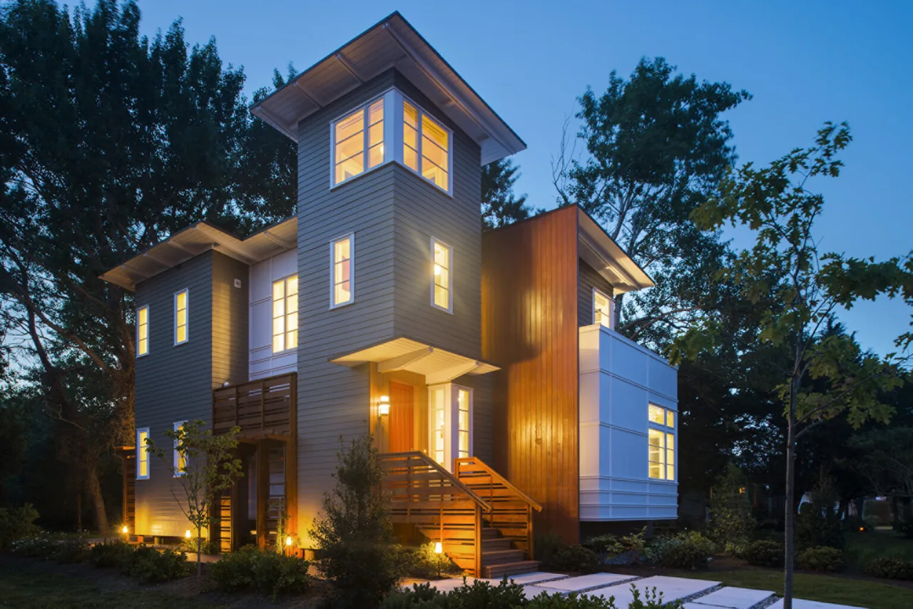 Night view of Prospect House featuring a three-story design with exterior lighting and a red front door.
