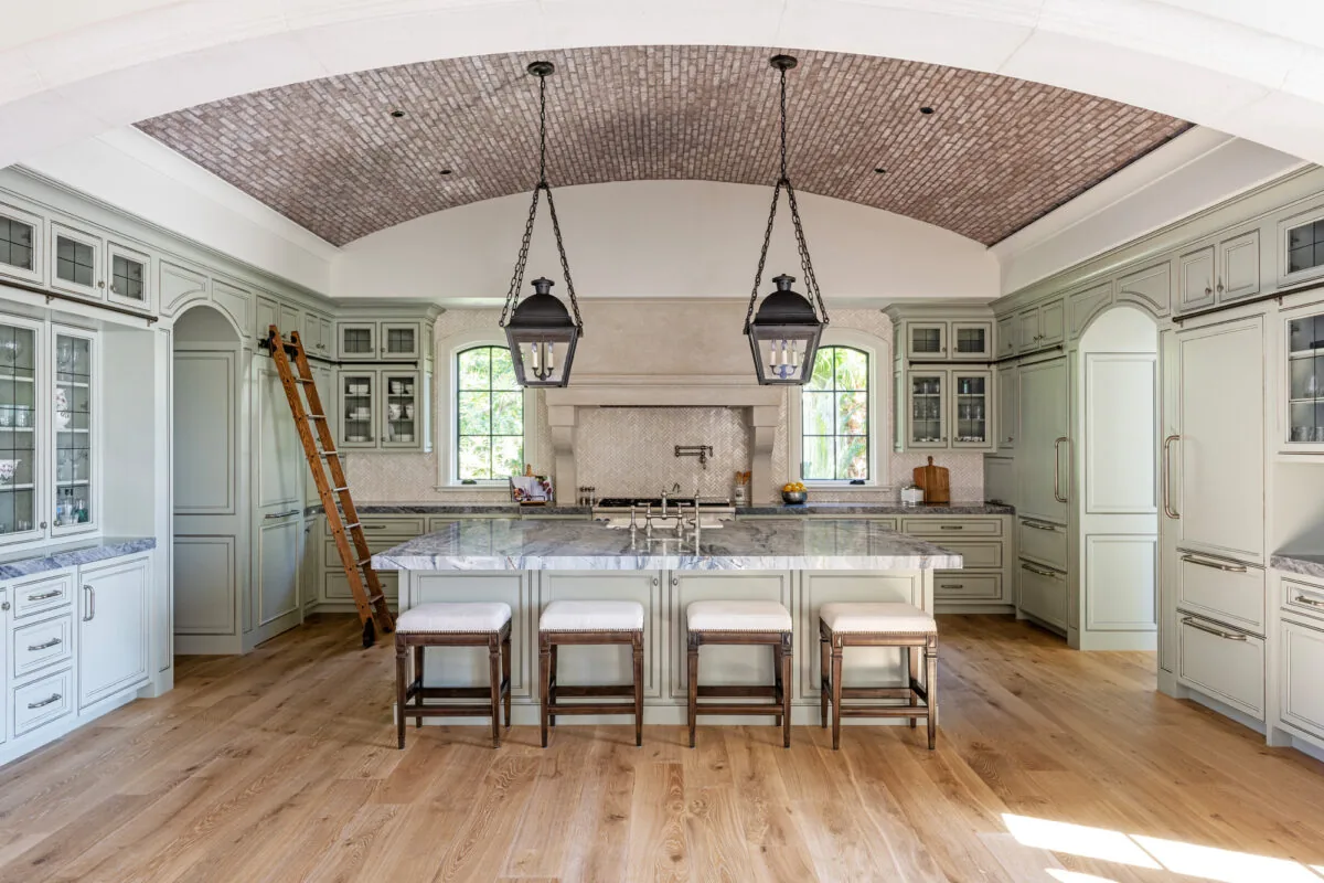 Kitchen interior with arched brick ceiling and marble countertop island in the French Countryside project by CMSA Architects.