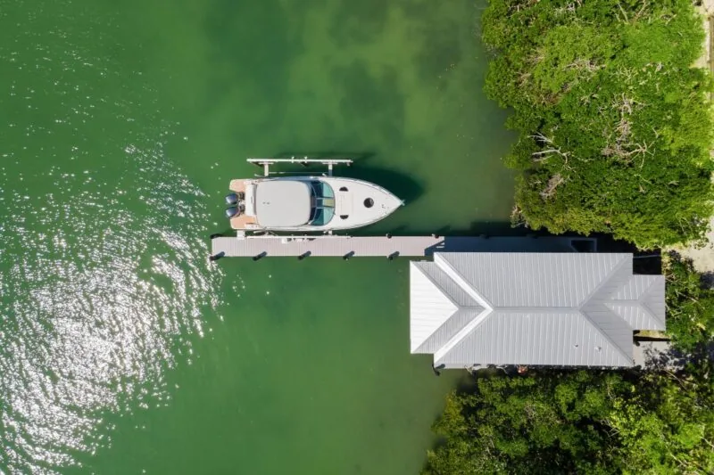 Overhead shot of the Tide House boat lift dock structure with a motorboat moored next to it in a waterfront setting.