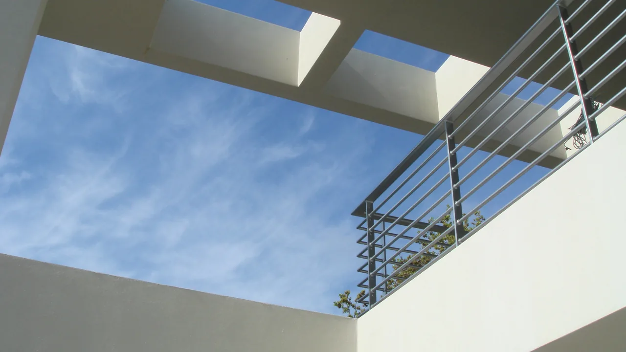 The Indian Beach Residence includes an exterior space with a large square skylight and horizontal metal railing.