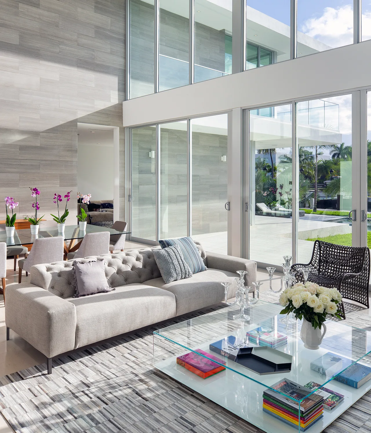 Living room of 301 Residence featuring floor-to-ceiling sliding glass doors and a serene tropical view outside.