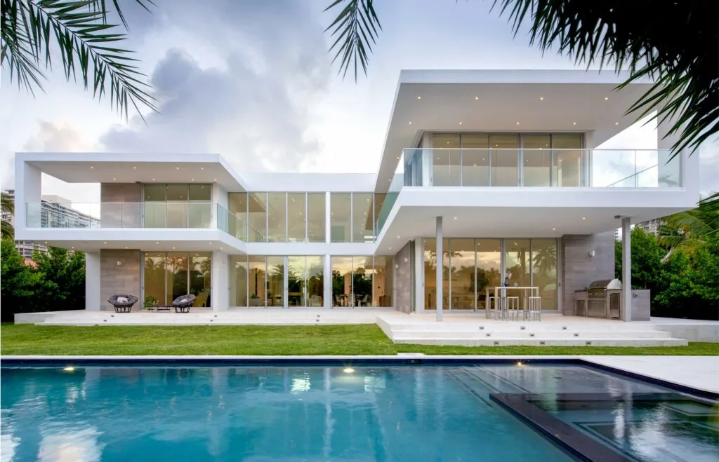 301 Residence features a modern design with prominent glass balcony railings and a flat roof overhang, alongside an outdoor pool area.