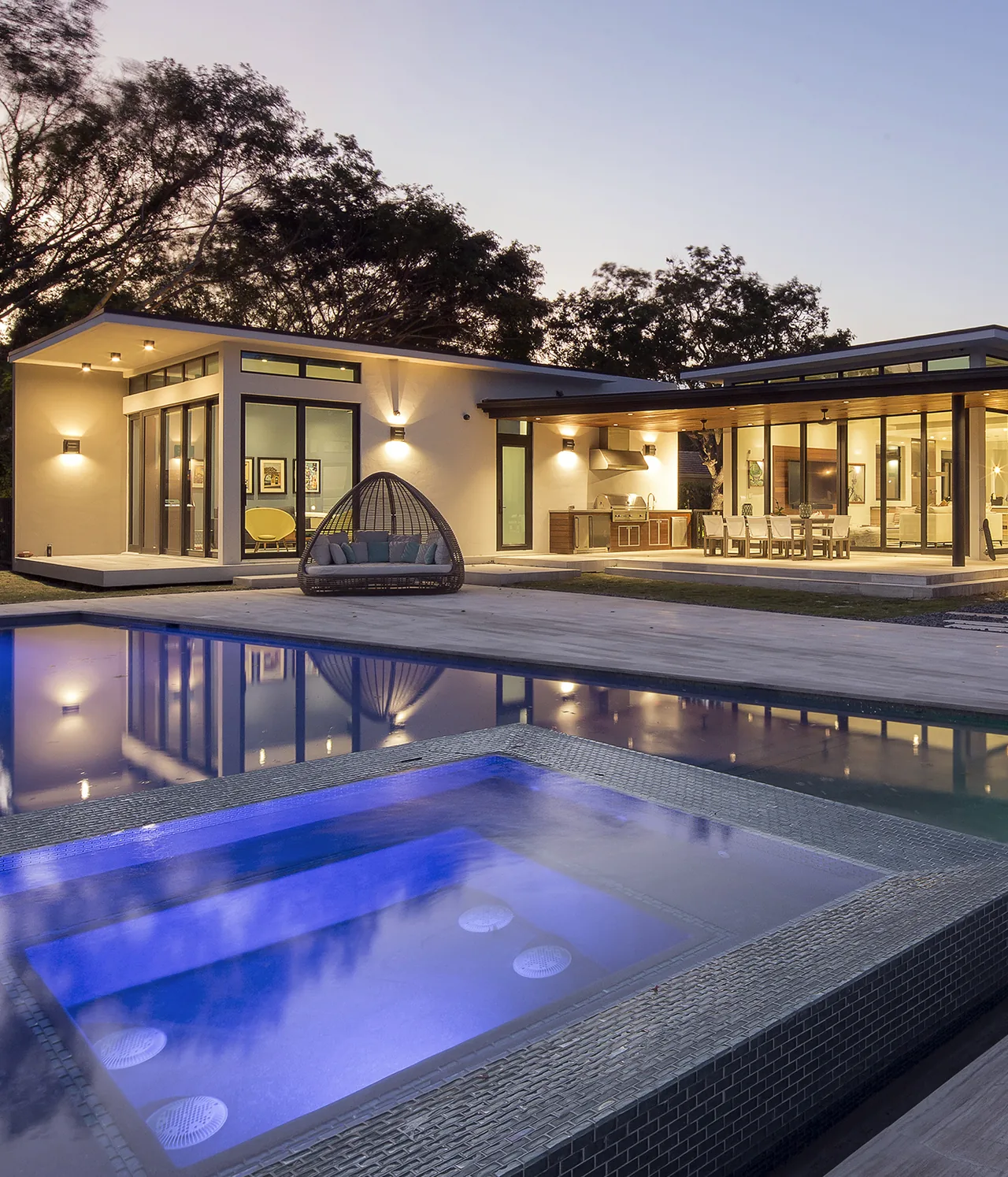 The ALF Residence features modern architecture with extensive glazing, outdoor kitchen, patio dining, and a pool with illuminated hot tub.