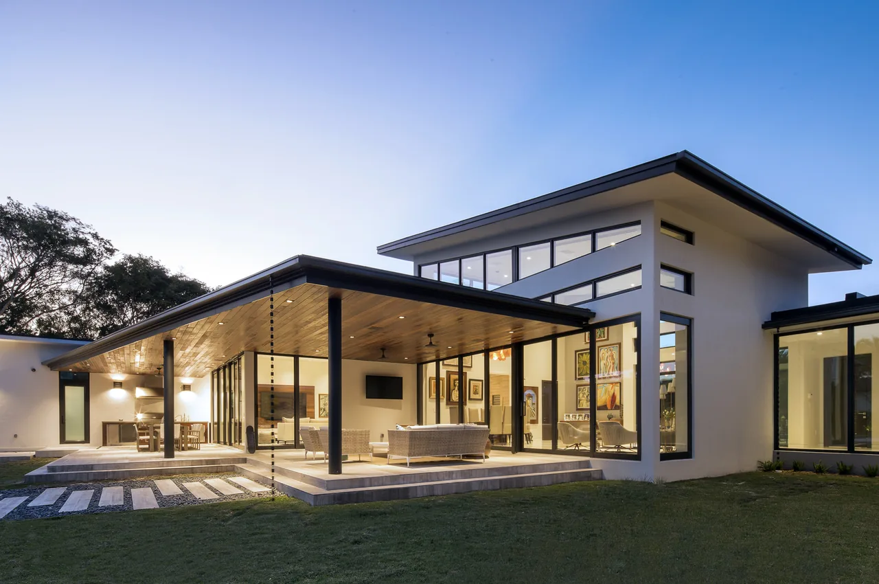 ALF Residence by SDH Studio Architecture + Design features a large cantilever roof covering an outdoor seating and kitchen area.