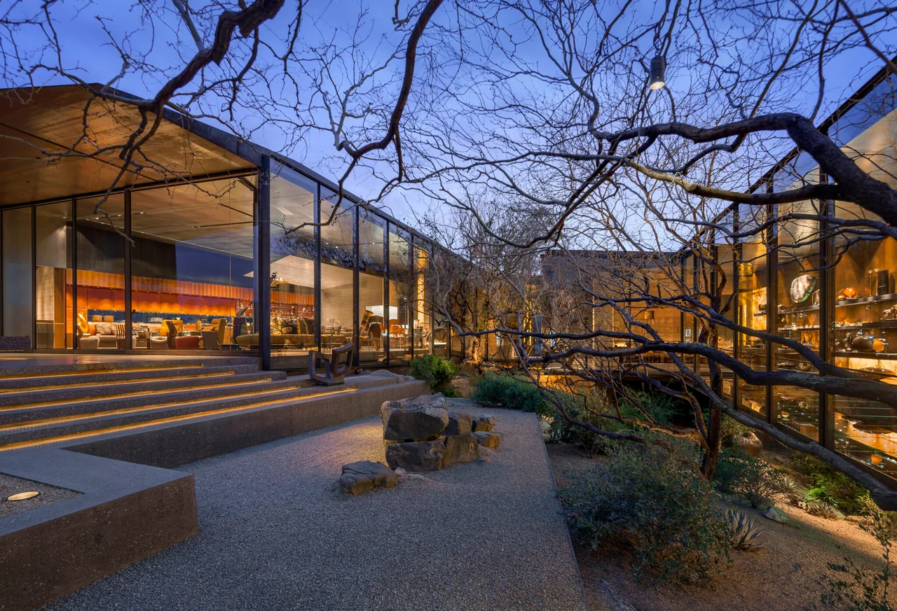 Desert Courtyard House features extensive floor-to-ceiling glass walls overlooking a natural courtyard.
