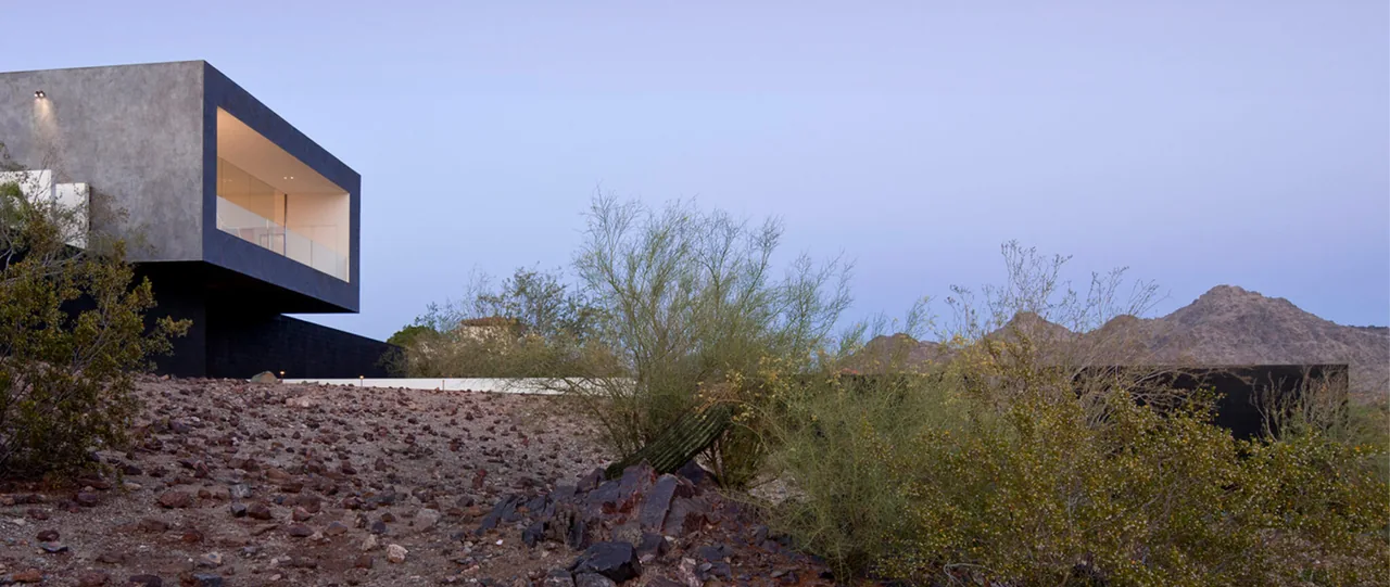 Dialogue House by Wendell Burnette Architects features a cantilevered upper floor with a balcony in a desert setting.