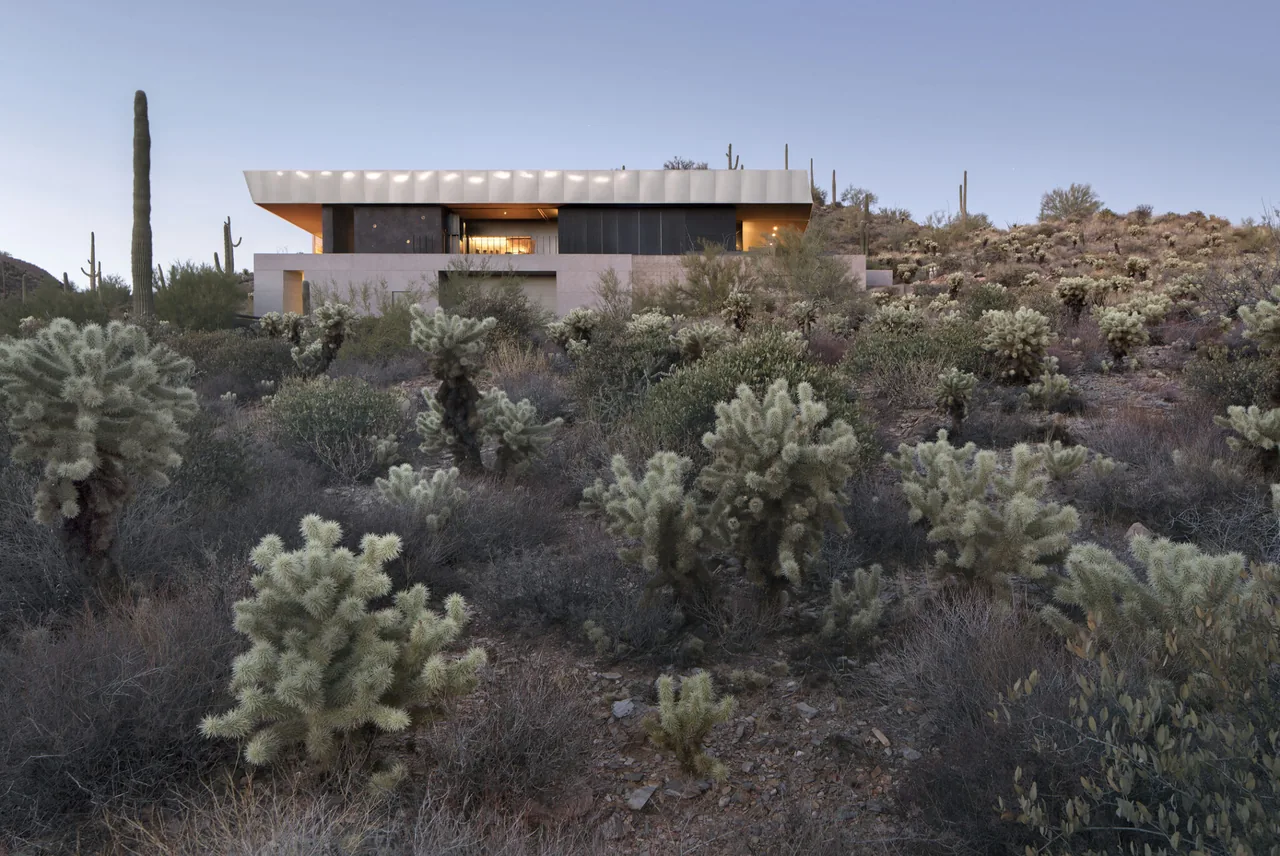 Hidden Valley Desert House from the rear with desert landscaping visible in the dusk light.