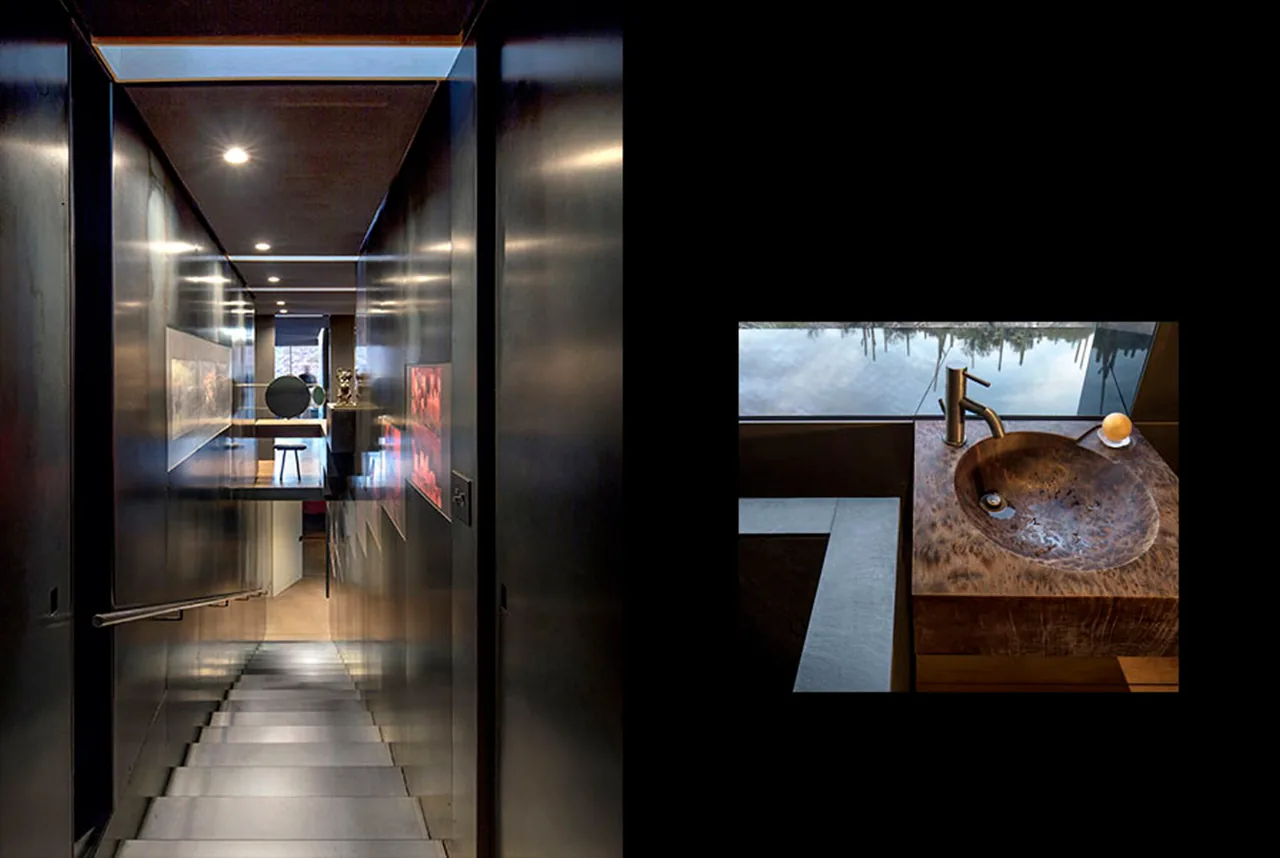 Interior stairway with dark reflective walls and recessed lighting in a desert house.