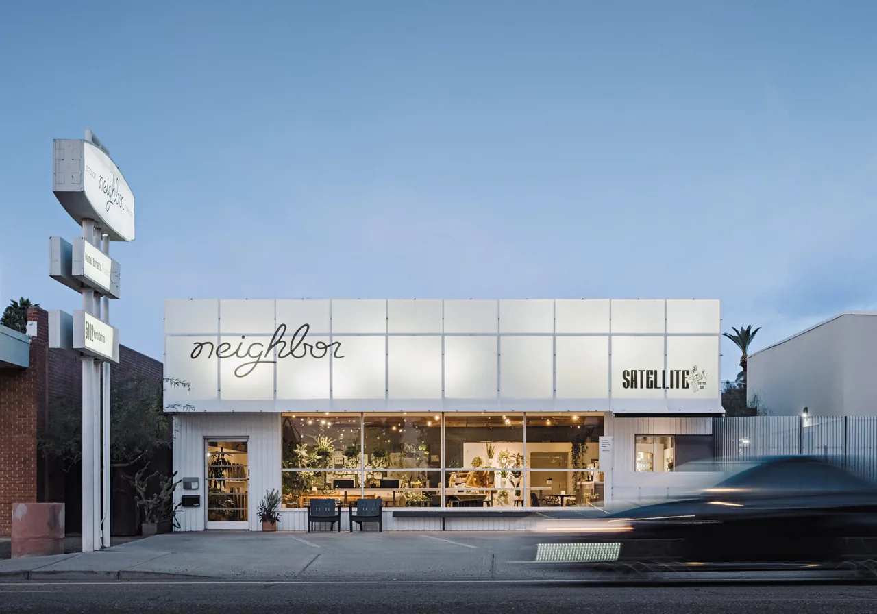 Contemporary storefront with illuminated facade panels and large display windows at street level.