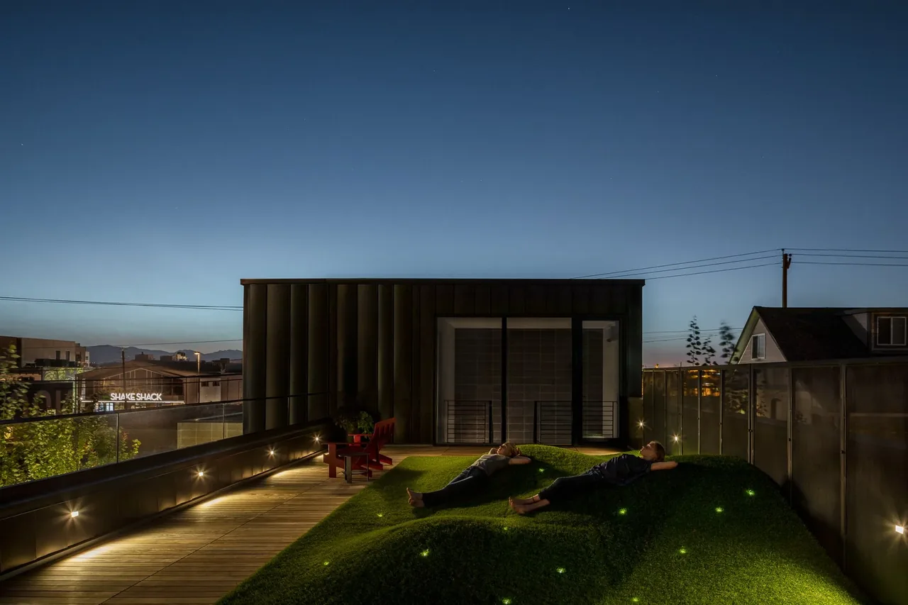 The RiNo residence features an open patio with landscaped yard and integrated exterior pathway lighting by DAVIS URBAN.