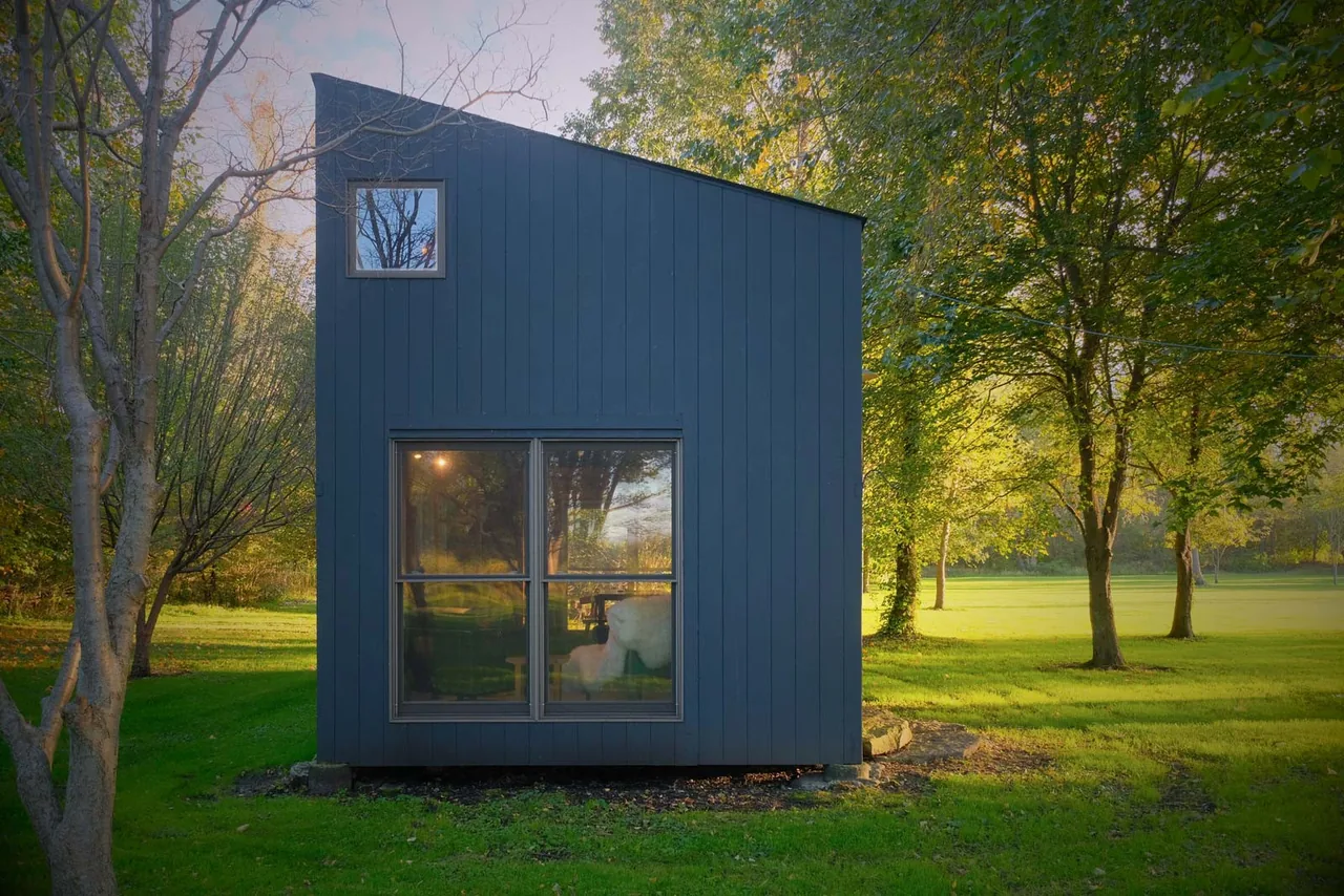 The Playhouse by Bamesberger Architecture features a small scale design with an asymmetrical roof and large windows.