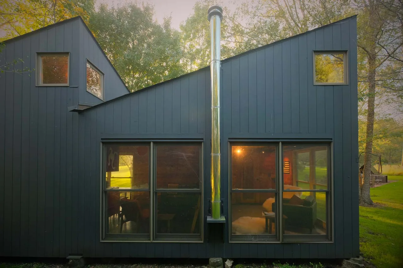 The Playhouse features an asymmetrical roof and large rectangular windows on its dark blue exterior.