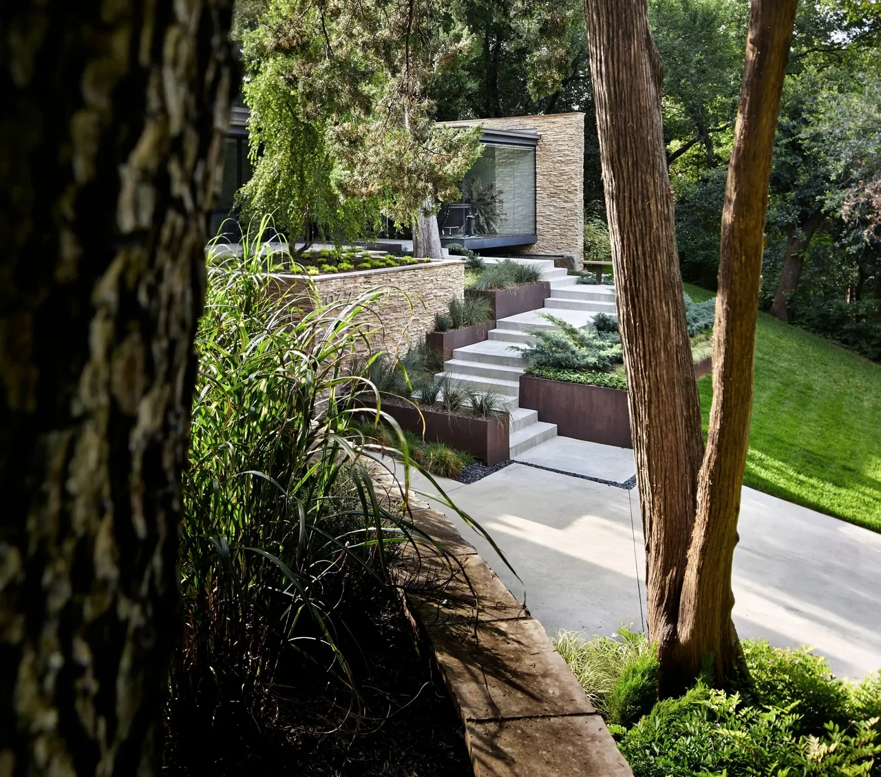 Kessler project features two-story architecture with concrete steps and lush landscaped planting in the front yard.