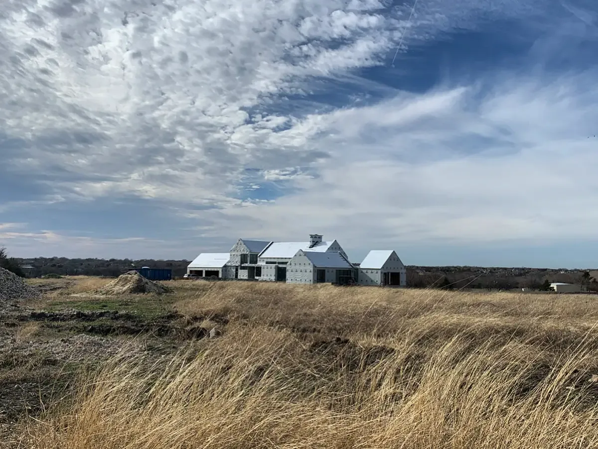 The Rabbit Ridge project shows a multi-gabled house in early construction stage amid an open field.