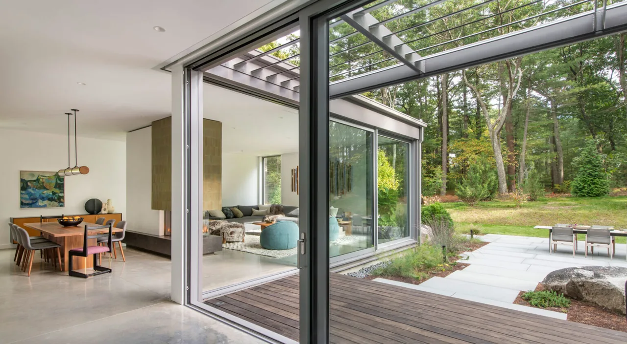 Noanet Woods Modern features floor-to-ceiling glazing and an open floor plan connecting interior and outdoor living spaces.
