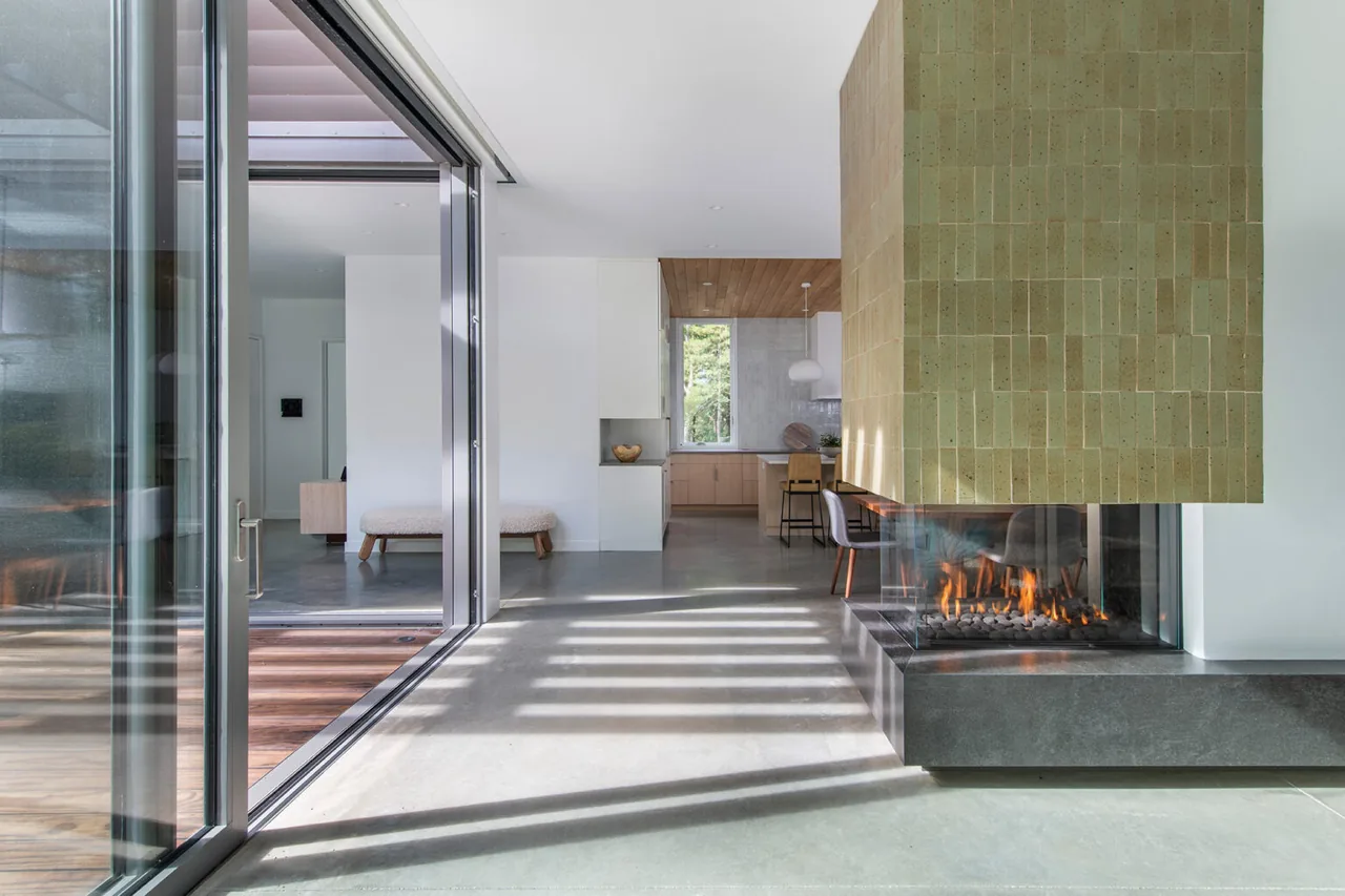 Modern interior featuring a gas fireplace with a tile surround and sliding glass door that opens to an outdoor space.