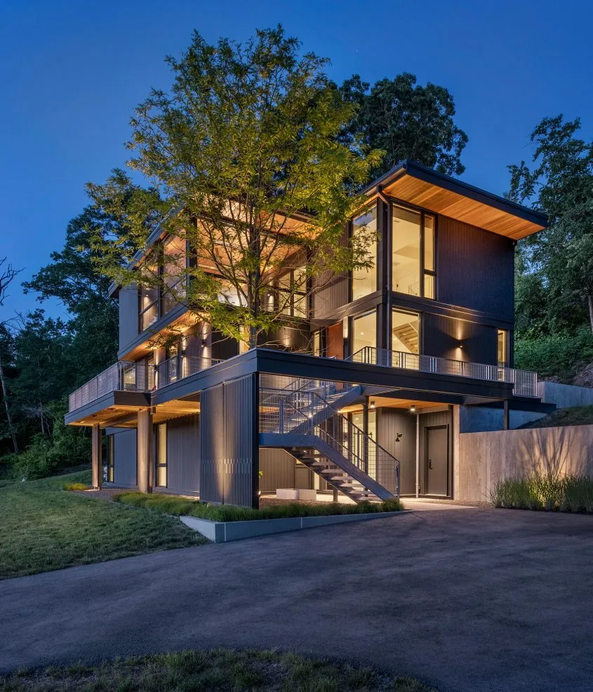 Tidal Marsh Overlook features a modern multi-story design with large glass windows and an exterior metal staircase.