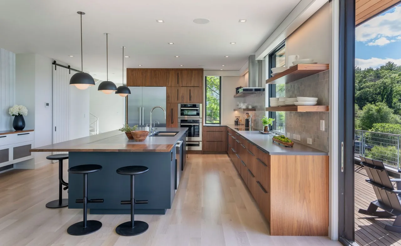 The Tidal Marsh Overlook kitchen features a spacious island, wood cabinets, and access to an outdoor deck with marsh views.