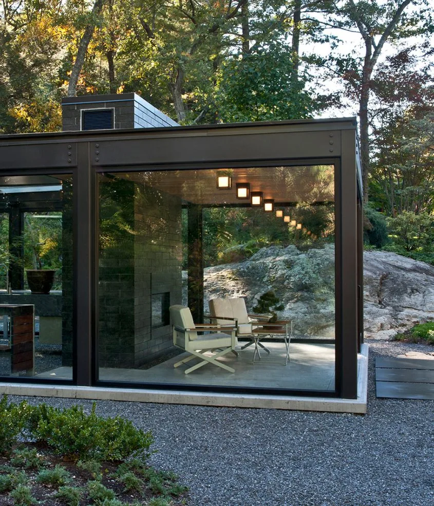 Modern Bonsai Greenhouse by Flavin Architects features large floor-to-ceiling glazing with black window frames and a flat roof.