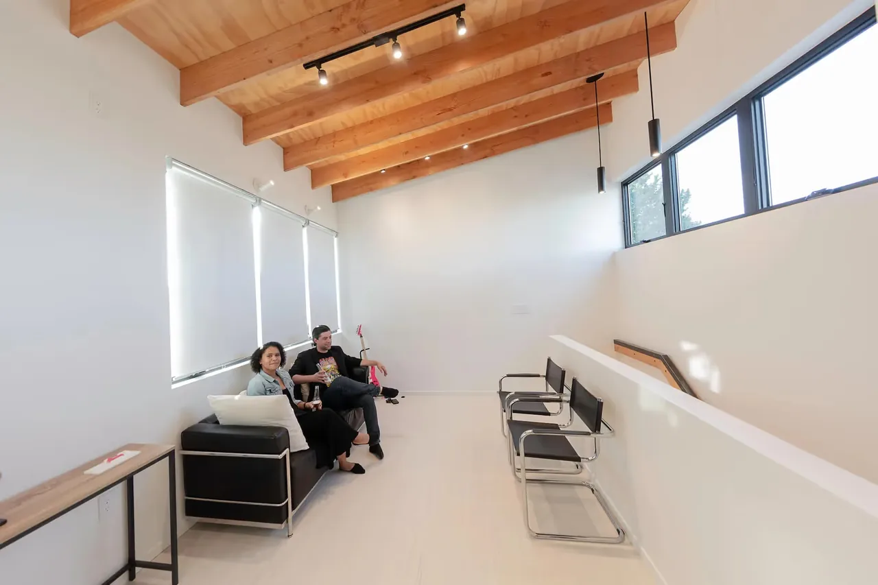 The living space in The Prince House ADU features exposed wood beams and high windows.