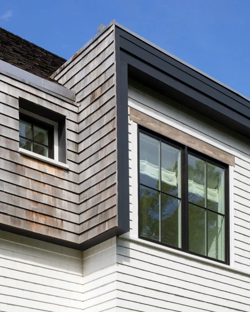 The Amagansett House features shingle siding and a gable roof with black window frames at the corner detail.