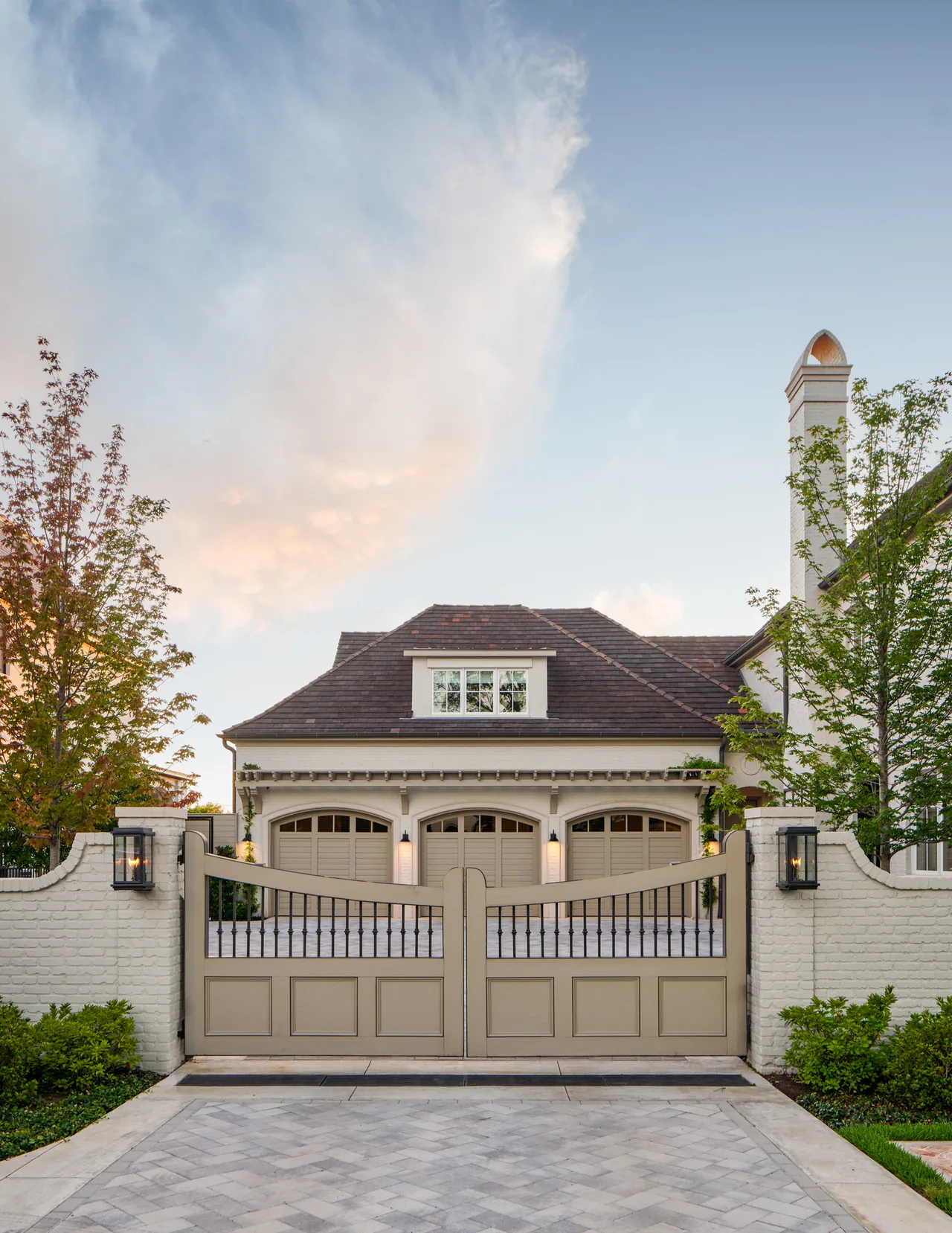 This image shows the gated entrance and three-car garage of the New Classic project by Blume Architecture in Dallas.