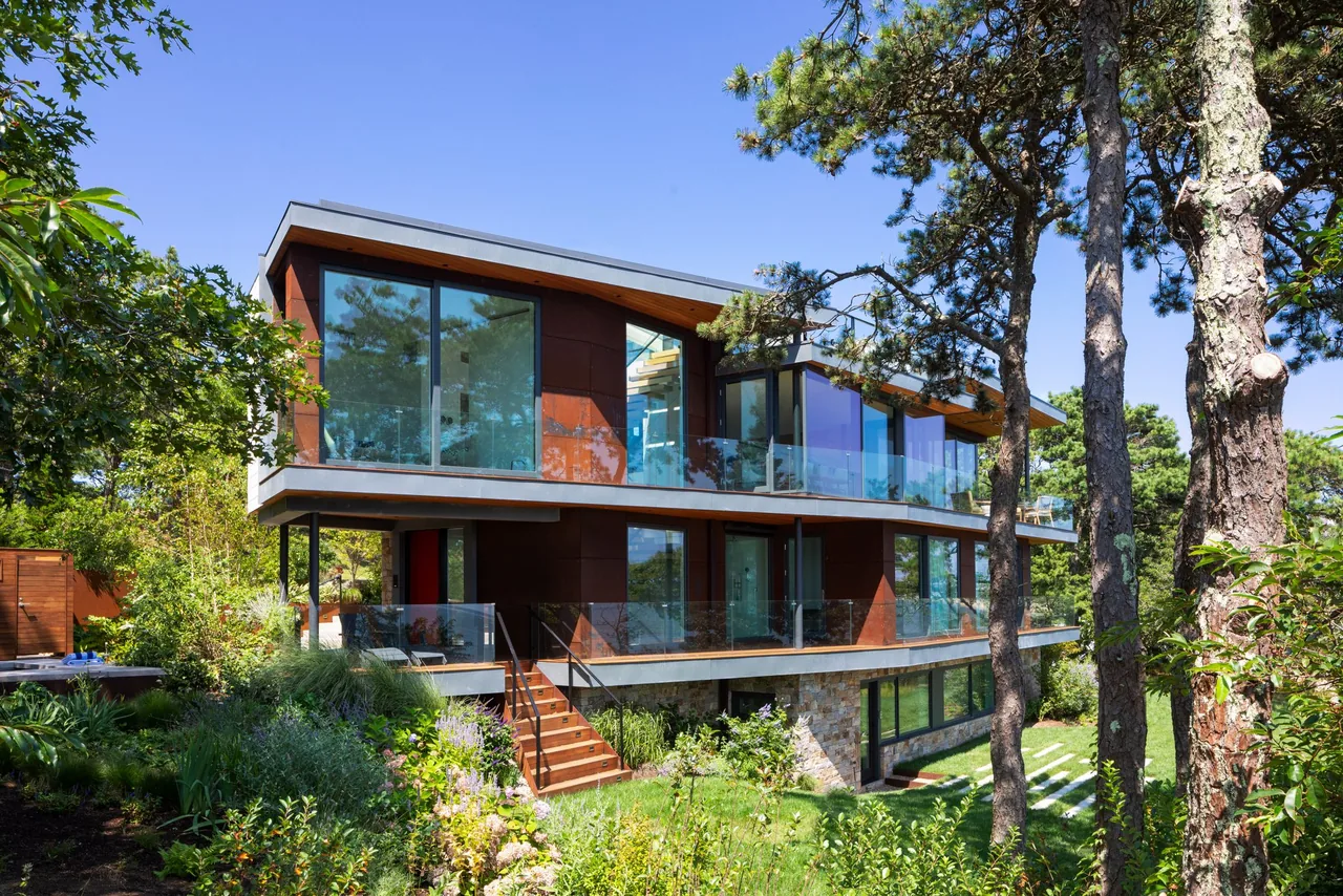 Miter Point features glass stair railings and exterior stair lighting, set among lush landscape plants.