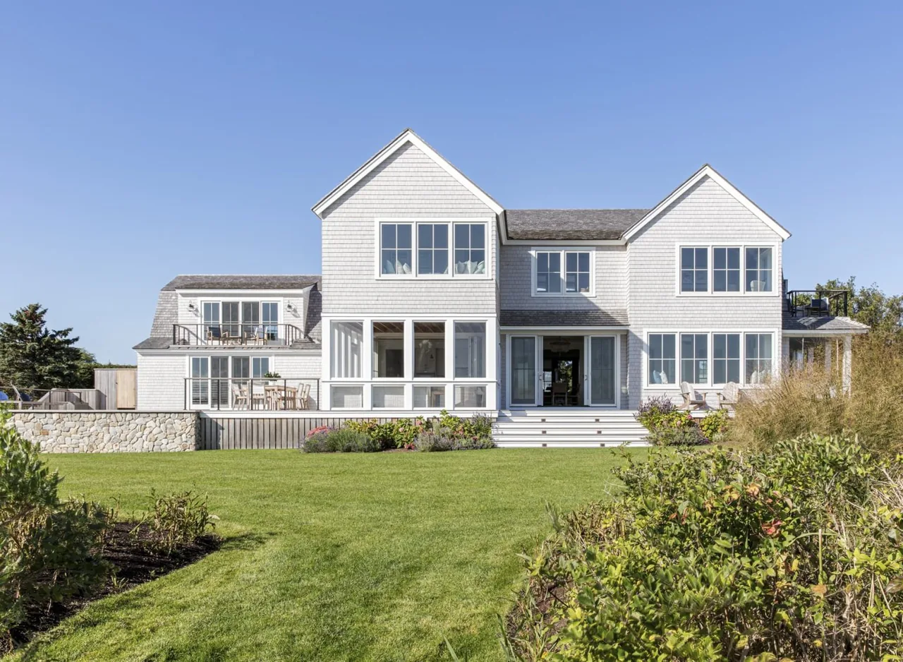 Rear exterior of Salten Point residence showing white shingle siding, gable roofs, and outdoor seating areas.