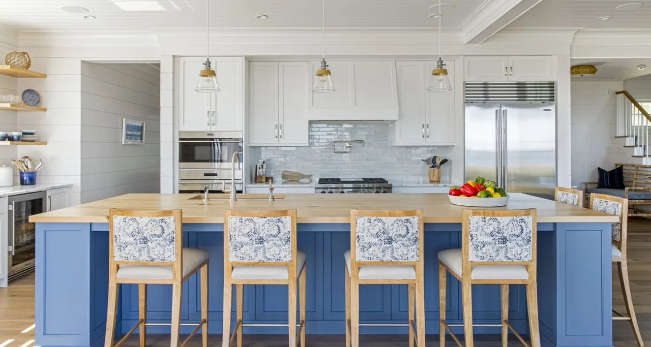 Kitchen features a large blue island with wood top, white cabinetry, stainless steel appliances, and three pendant lights.