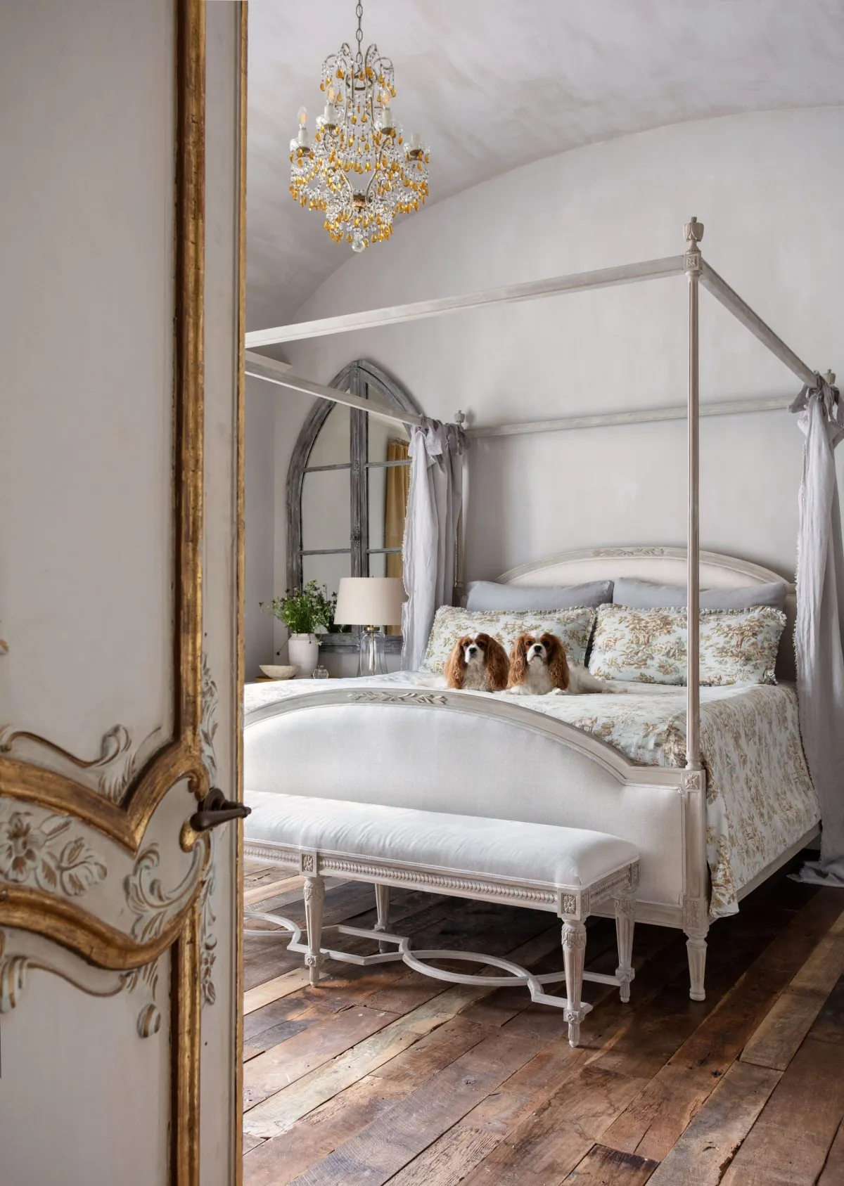 Old-World French Estate bedroom featuring a canopy bed with floral bedding and a crystal chandelier above.