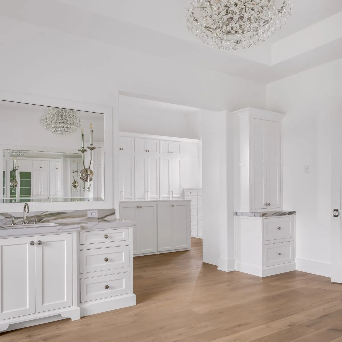 Bathroom featuring white cabinetry, marble countertops, wood flooring, and a large mirror.