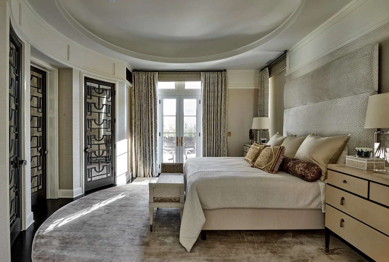 The LAKEWOOD RESIDENCE bedroom features a large upholstered bed and black metal patterned doors by dSPACE Studio in Chicago.