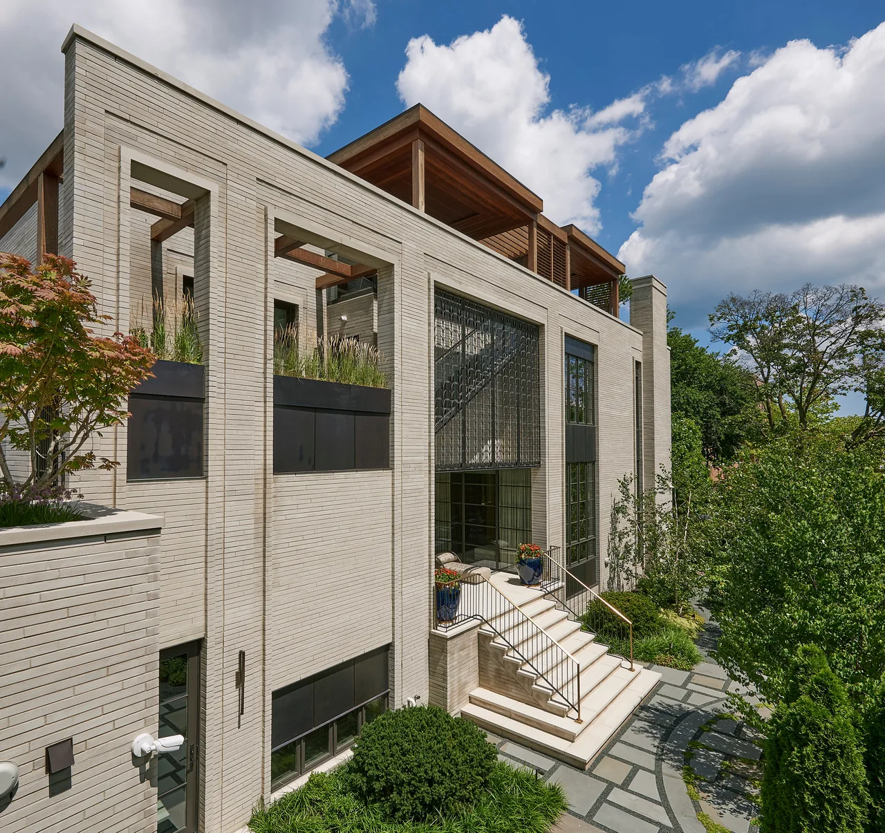 The LAKEWOOD RESIDENCE features a symmetrical light brick facade with ornamental metal door and landscaped front yard pathway.