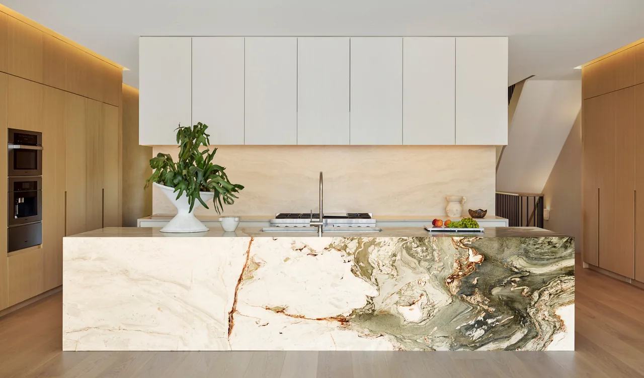 The Howe Street project kitchen features a marble island with natural patterning and wood cabinetry.