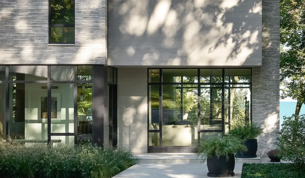 The Ravine Reimagined project features clean-lined exterior with large black window frames and integrated landscaping.